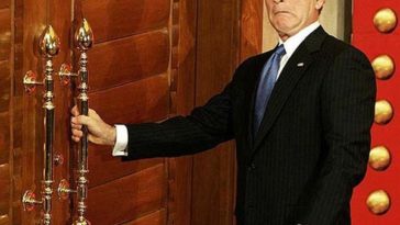 US President George W. Bush reacts as he tries to open a locked door after a news conference in Beijing